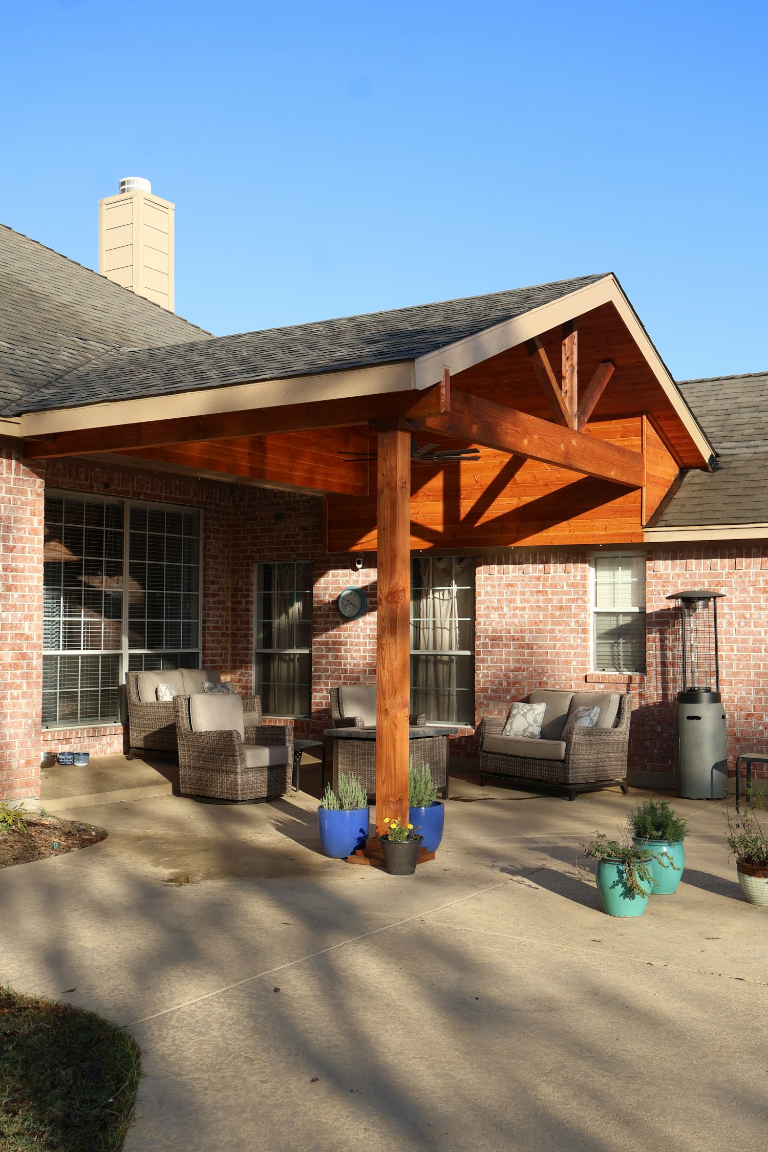 A brick home with a covered timber patio and outdoor furniture