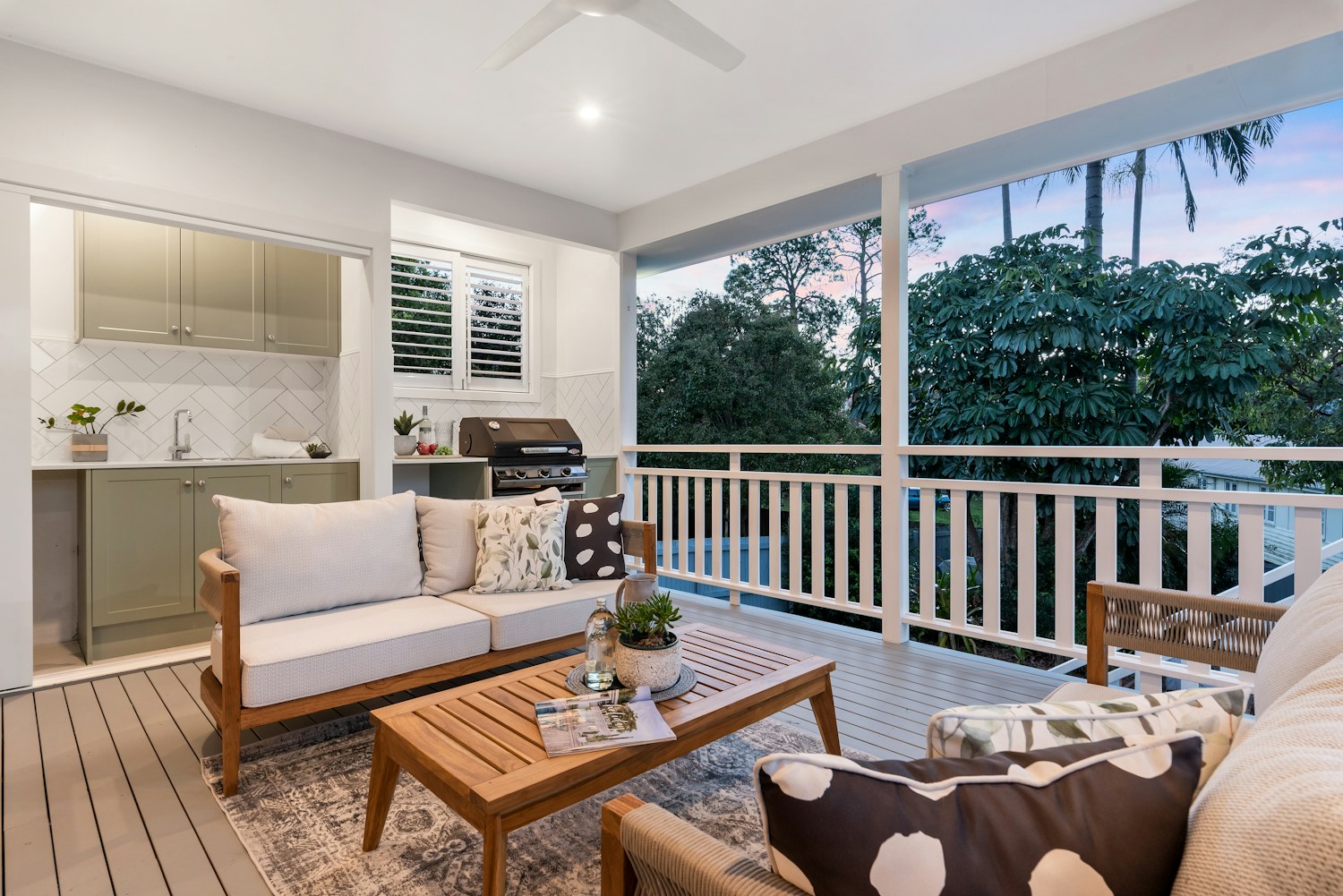 A pale outdoor sofa beside a low wood coffee table