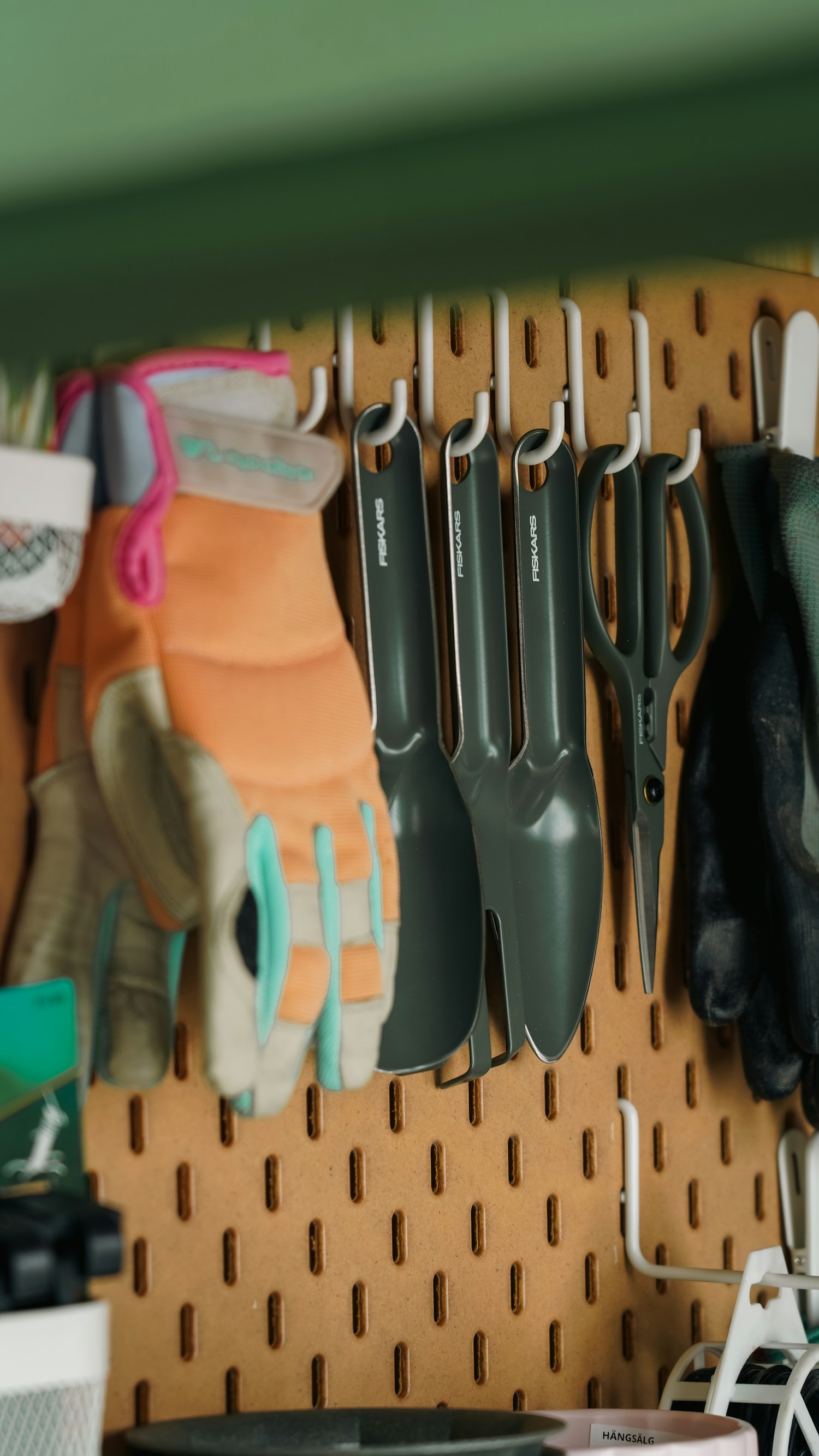 Gardening tools and gloves neatly organized on a pegboard