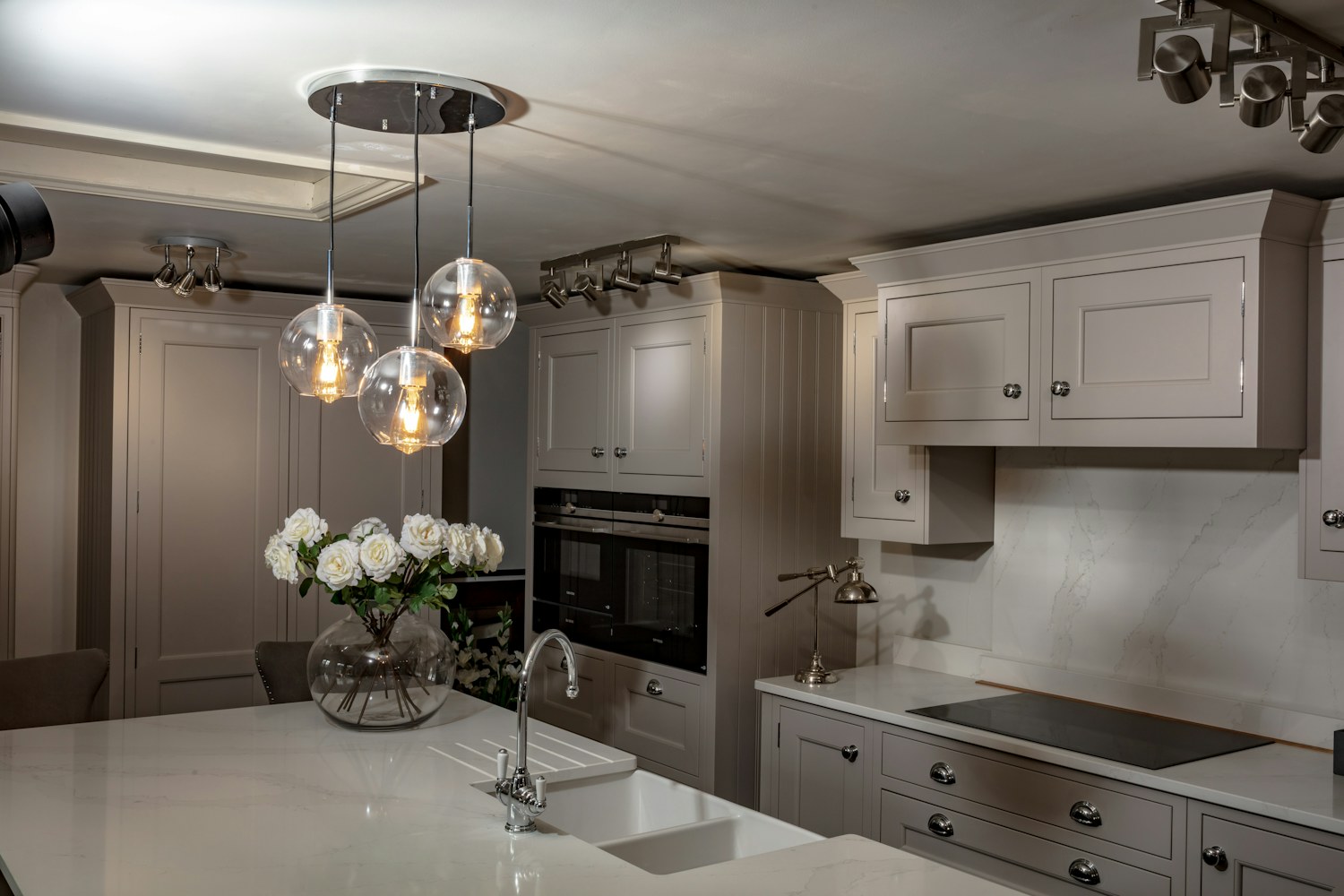 A large kitchen with a center island and decorative ceiling light