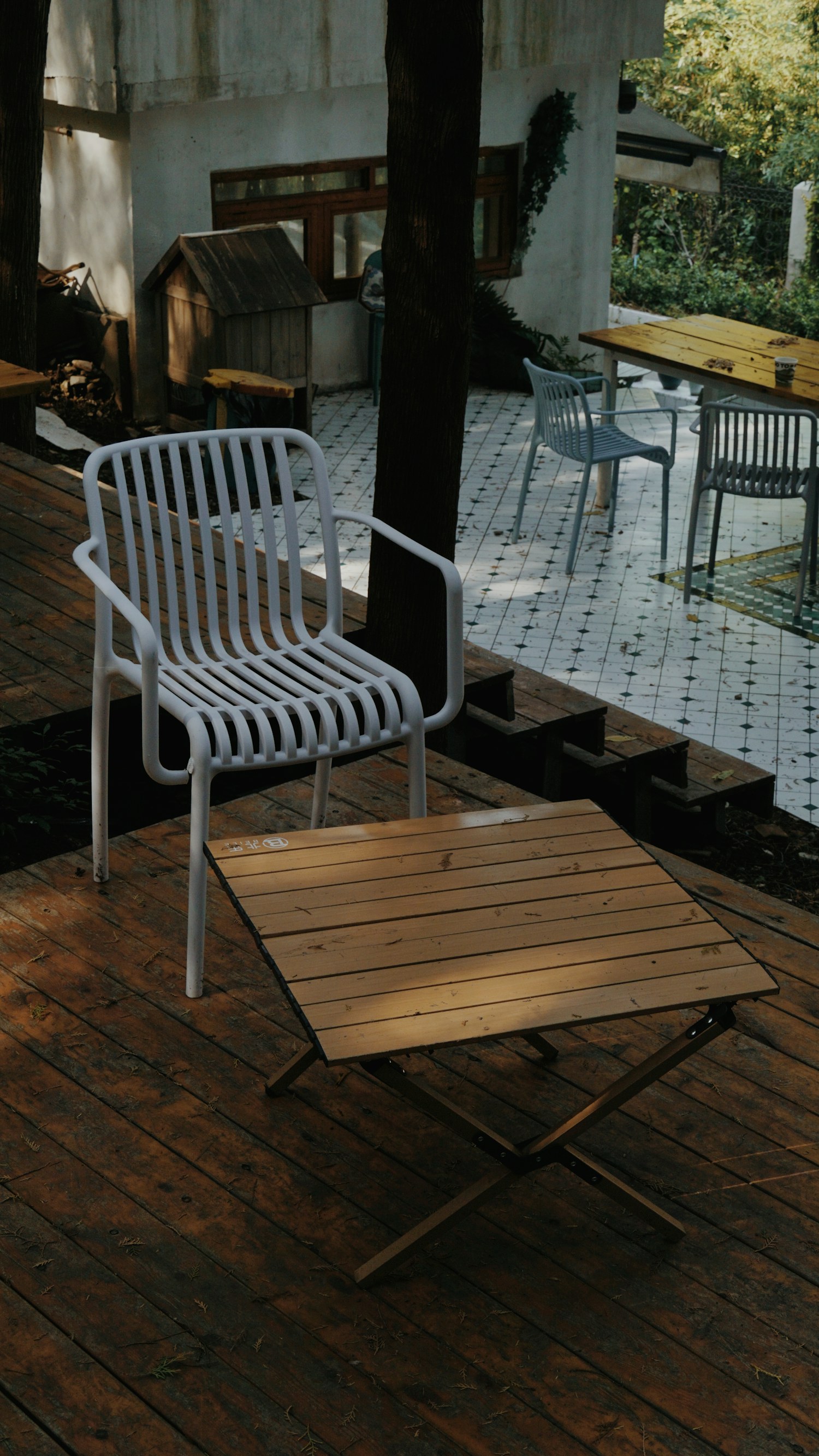 A white chair and wood table on a deck
