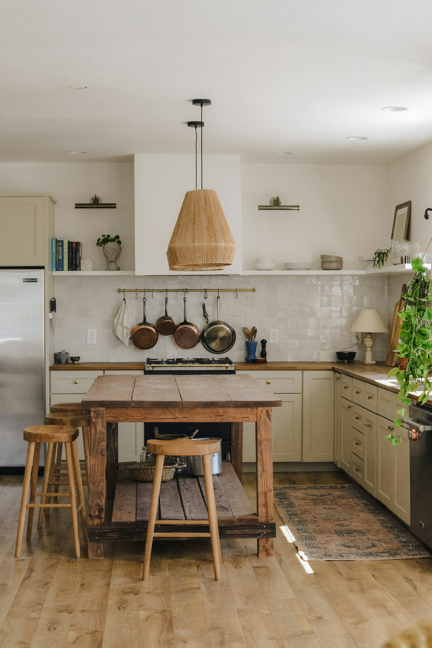 A rustic kitchen with a wood island and counter stools